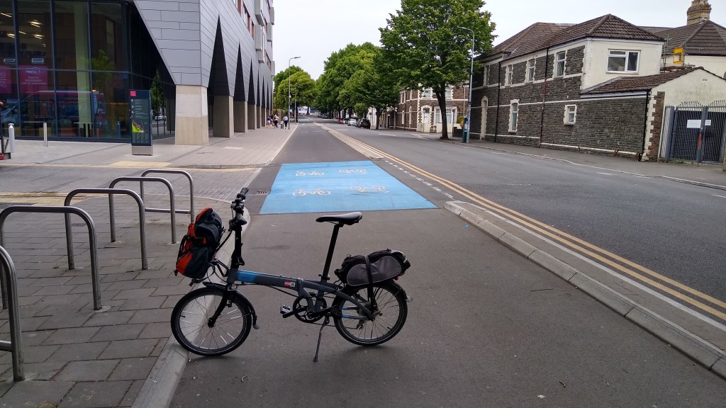 A cycle track with a bike parked across it. The kerbs either side are sloping at 45 degrees down to the cycle track.