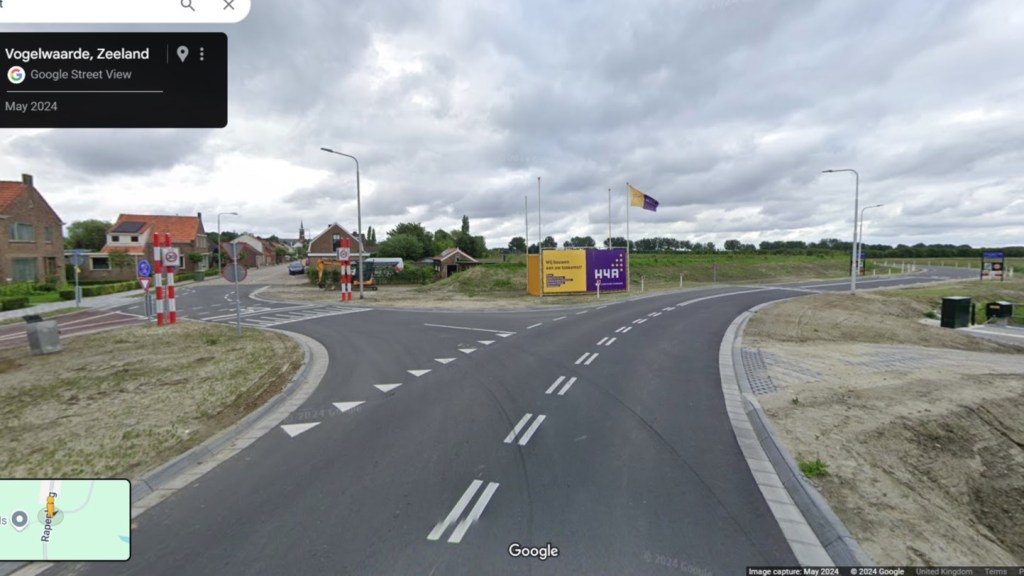 A T-junction with the main road curving right and a side road to the left to enter a village.