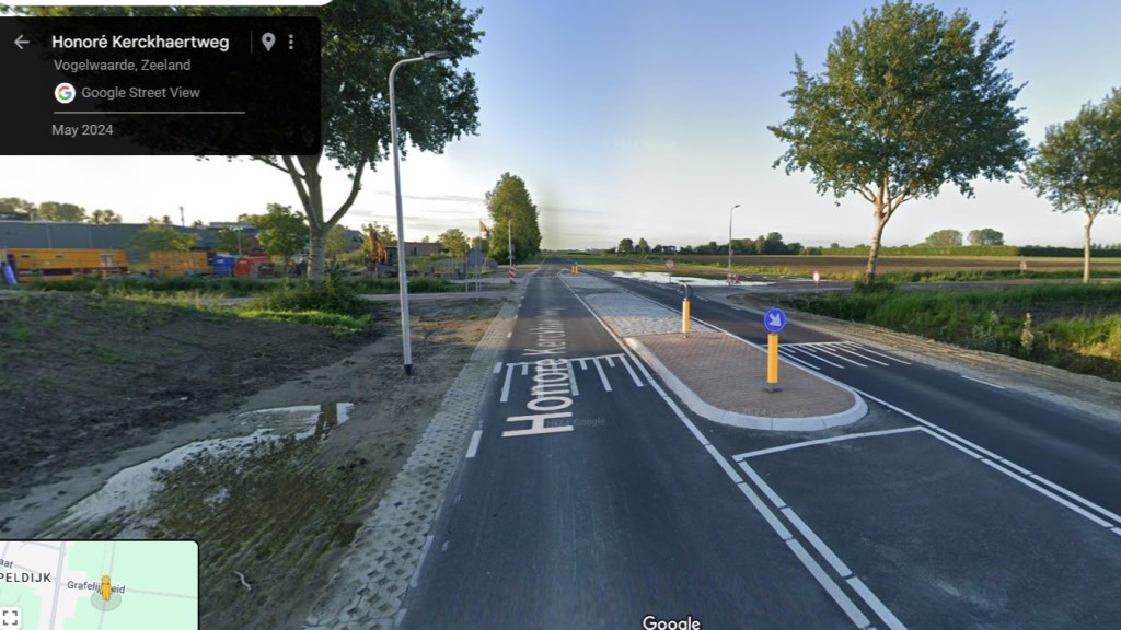 A two-way rural road with a wide traffic island in he middle.